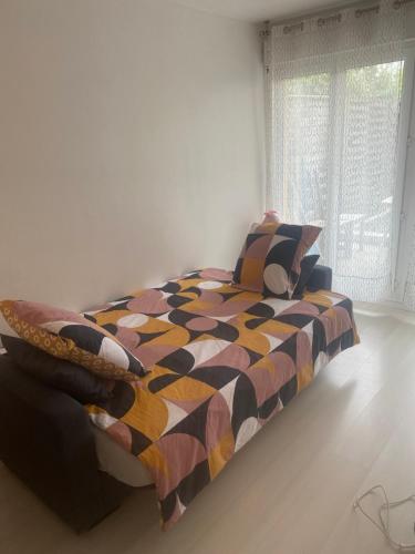 une chambre avec un lit avec une couette colorée et une fenêtre dans l'établissement Le petit nid de Disney3min, Rer1min, Paris35min, à Chessy