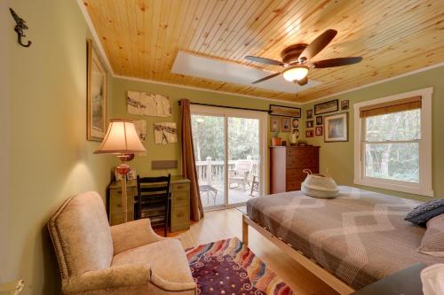 a bedroom with a bed and a ceiling fan and a chair at Creekside Newland Cabin about 7 Mi to Linville Falls in Newland