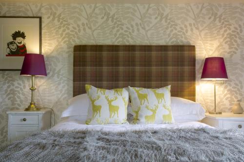 a bedroom with a bed with pillows and two lamps at Pear Tree Inn Whitley in Whitley