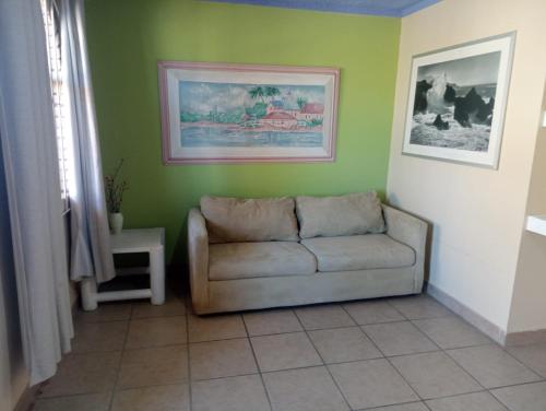 a living room with a couch in a green wall at Departamento #7 in San Felipe