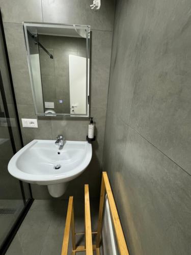 un baño con lavabo y espejo en Old Bazaar studio, en Tirana