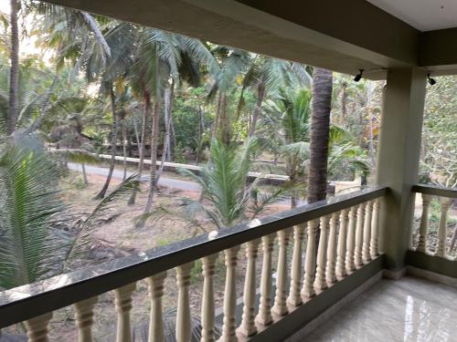 a balcony with a view of the palm trees at Gonsalves Villa in Cansaulim