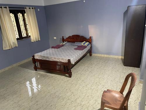 a bedroom with a bed and a chair at Gonsalves Villa in Cansaulim
