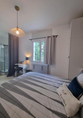 une chambre avec un grand lit et un bureau dans l'établissement MAISON 5 CHAMBRES Le séjour familiale sur le côte d'émeraude 5 min du centre ville RESSOURCEZ VOUS, à Dinard