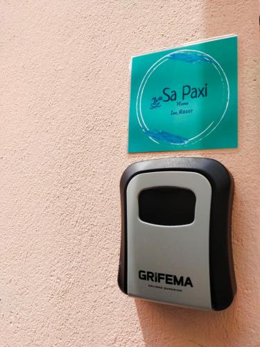 a soap dispenser attached to a wall with a card at Sa Paxi Arbus in Arbus