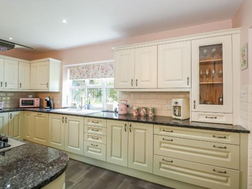 a kitchen with white cabinets and black counter tops at The Granary in Boston