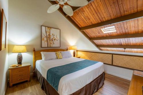 a bedroom with a bed and a wooden ceiling at Hale Mahina B403- Beautiful 2 bedroom oceanfront condo, private beach, farmers market, and more in Kahana