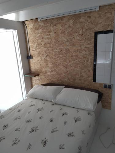 a bedroom with a bed and a brick wall at A Cascada do Ézaro in Dumbría
