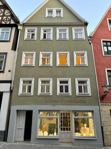 a green building with white windows at Individuelle und zentrale Boho Appartments in Coburg in Coburg