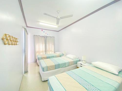 una camera da letto con due letti e un ventilatore a soffitto di San Marco Villa 3 - Burrum Heads - Beachfront - 2BR - Pool a Toogoom