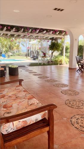 a living room with two wooden benches and a tile floor at Amazing Beachfront Villa - Palm House in Punta Chame