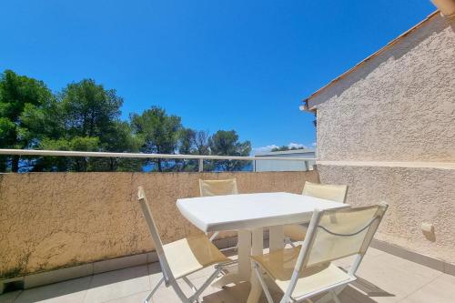 une table blanche et des chaises sur un balcon dans l'établissement Seafront apartment 4 people in domain - 2 Pools, à Saint-Raphaël