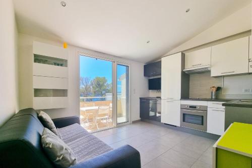 un salon avec un canapé et une cuisine dans l'établissement Seafront apartment 4 people in domain - 2 Pools, à Saint-Raphaël