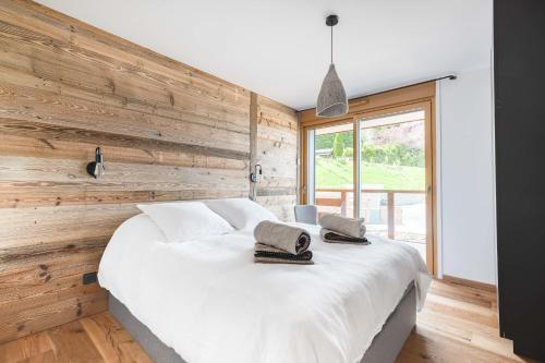 - une chambre avec un grand lit blanc et des murs en bois dans l'établissement Appartement Boréal - At the summit of Combloux, à Combloux