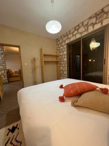 a bedroom with a large white bed with a red pillow at Le Réel Kaouki in Sidi Kaouki