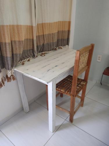 a white table with a chair and a window at Pousada Viva Praia in Paracuru