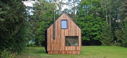 a small wooden house in the middle of a field at Dom w lesie in Przytuły