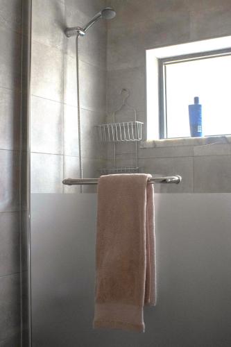 a bathroom with a shower with a towel on a towel rack at Casa da Avó Bé in Portalegre