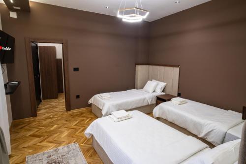 a hotel room with three beds in a room at Trpeza Luxury Apartments, free parking in Niš