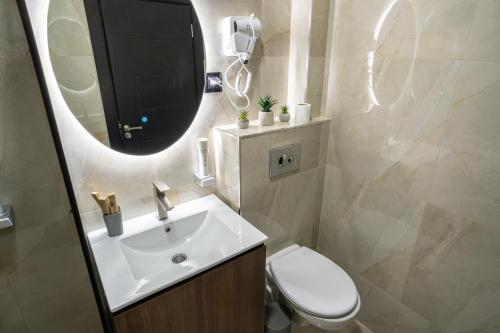 a bathroom with a sink and a toilet and a mirror at Trpeza Luxury Apartments, free parking in Niš