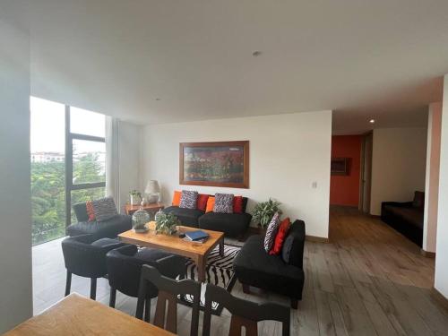 a living room with a couch and a table and chairs at DN3A Spacious apartment in Cayalá with pool in Guatemala