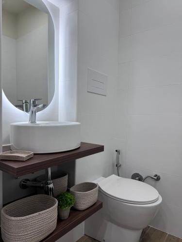 a bathroom with a sink and a toilet and a mirror at Tecla Apartment in Reggio di Calabria