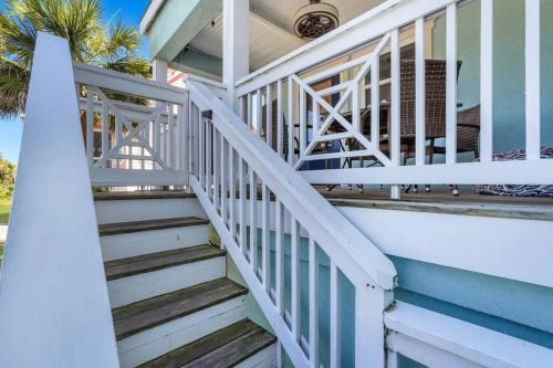 a white staircase on a house with palm trees at Blue Pearl Beach House Steps from Beach Access in Tybee Island
