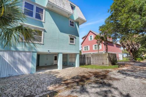 a blue house and a pink house at Blue Pearl Beach House Steps from Beach Access in Tybee Island