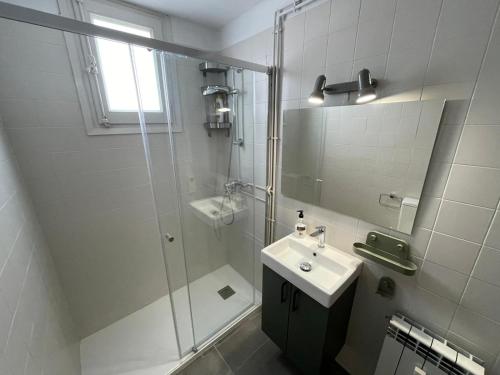 a bathroom with a glass shower and a sink at Apartamento DALIA in La Molina