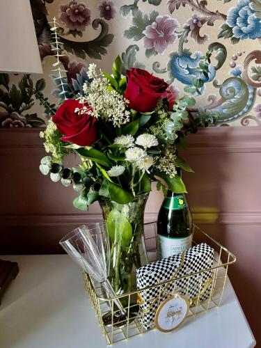 a vase of flowers and a bottle of wine on a table at Art City Inn in Springville
