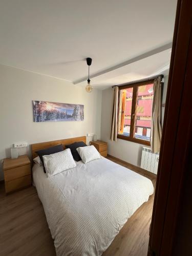 a bedroom with a large bed and a window at Apartamento DALIA in La Molina