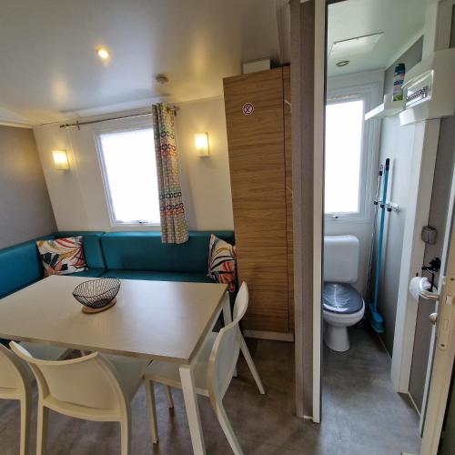 Cette petite chambre dispose d'une table, de chaises et de toilettes. dans l'établissement MH2-CONFORT- 3CH - 6 pl - TV- LAVE VAISSELLE - WI-FI - 