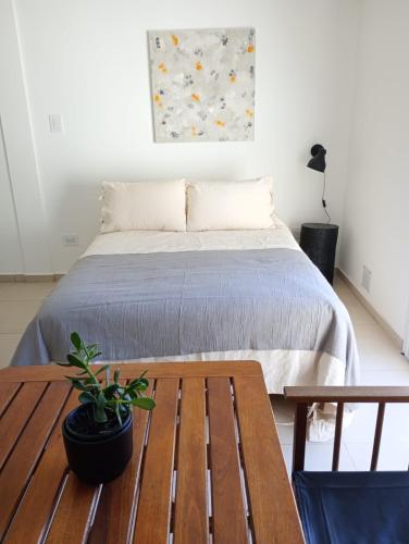 a bedroom with a bed and a wooden table at Monoambientes MOKA in Concepción del Uruguay