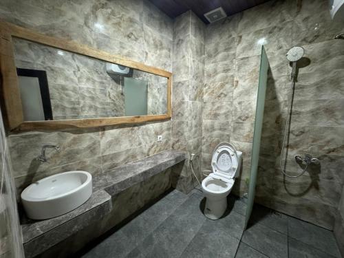 a bathroom with a sink and a toilet and a mirror at Villa Umah Seminyak in Seminyak