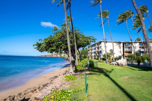 a hotel on the beach with palm trees at Kanai A Nalu 310 in Wailuku