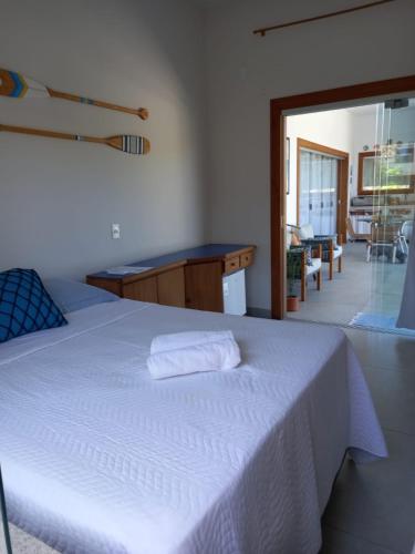 a bedroom with a white bed and a balcony at Brisa Mar Suítes in Arraial d'Ajuda