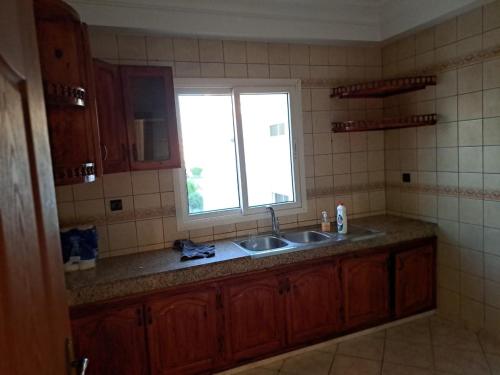 a kitchen with a sink and a window at Vue sur mer in El Harhoura