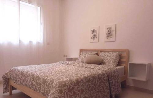 a bedroom with a bed and a window at Vue sur mer in El Harhoura