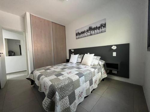 a bedroom with a bed with a quilt on it at Terra Malbec in Godoy Cruz