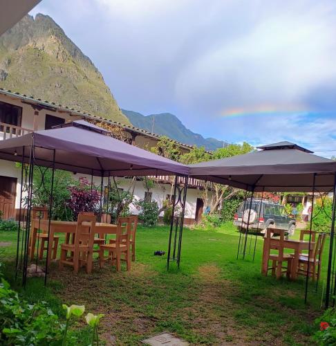 a group of tables and chairs under umbrellas at Sequeiros Garden in Ollantaytambo