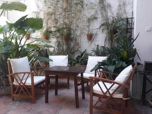 a patio with a table and chairs and plants at Hostal Gran Capitan in Chipiona