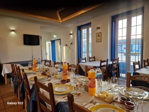a dining room with a long table with plates and glasses at LOUSAL TENTS Grandola in Lousal
