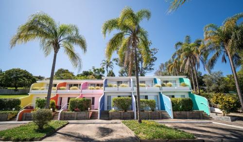 a colorful building with palm trees in front of it at The Cubana Resort Nambucca Heads in Nambucca Heads
