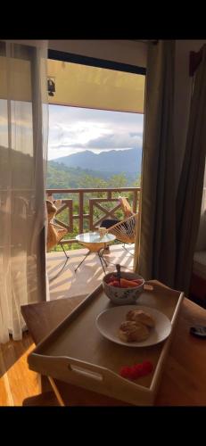 a table with a plate of food on a balcony at Bungalows Paraíso Celeste in Bijagua