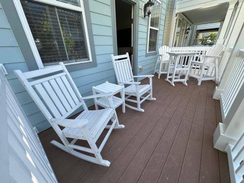 a row of white rocking chairs on a porch at Sunset Island - 35 Seaside in Ocean City