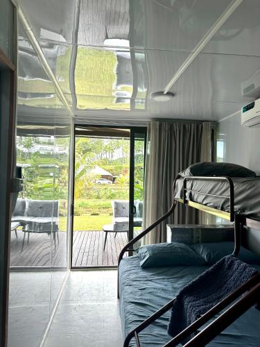 a bedroom with a bunk bed and a patio at Furnished Modern Farm Flat Tuvurara Savusavu Jasmeeruls Bayt in Nakasa