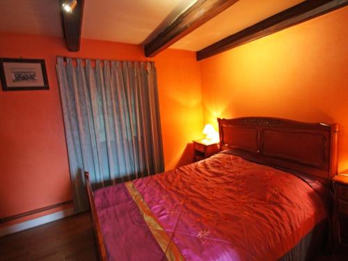 - une chambre avec des murs orange, un lit et une fenêtre dans l'établissement Charmant gîte avec terrasse, WiFi et garage moto à Gérardmer - FR-1-589-133, à Gérardmer