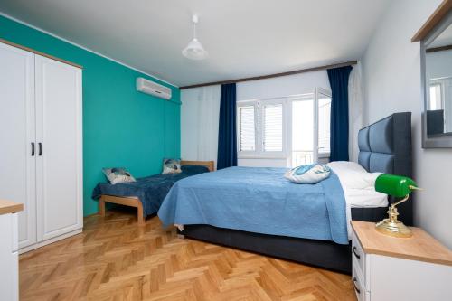 a bedroom with two beds with blue walls and wooden floors at Seaside holiday house Zubovici, Pag - 22859 in Zubovići