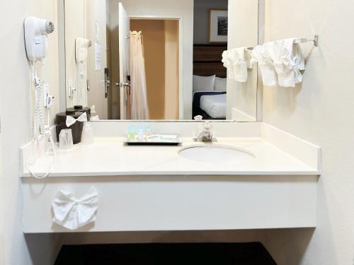 a white bathroom with a sink and a mirror at BayVue Hotel, Resort & Suites in Ocean Shores