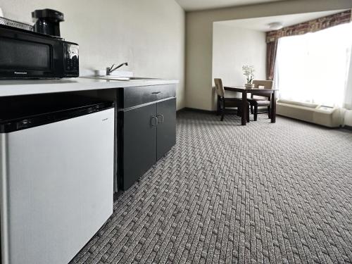 a room with a kitchen with a microwave and a table at BayVue Hotel, Resort & Suites in Ocean Shores